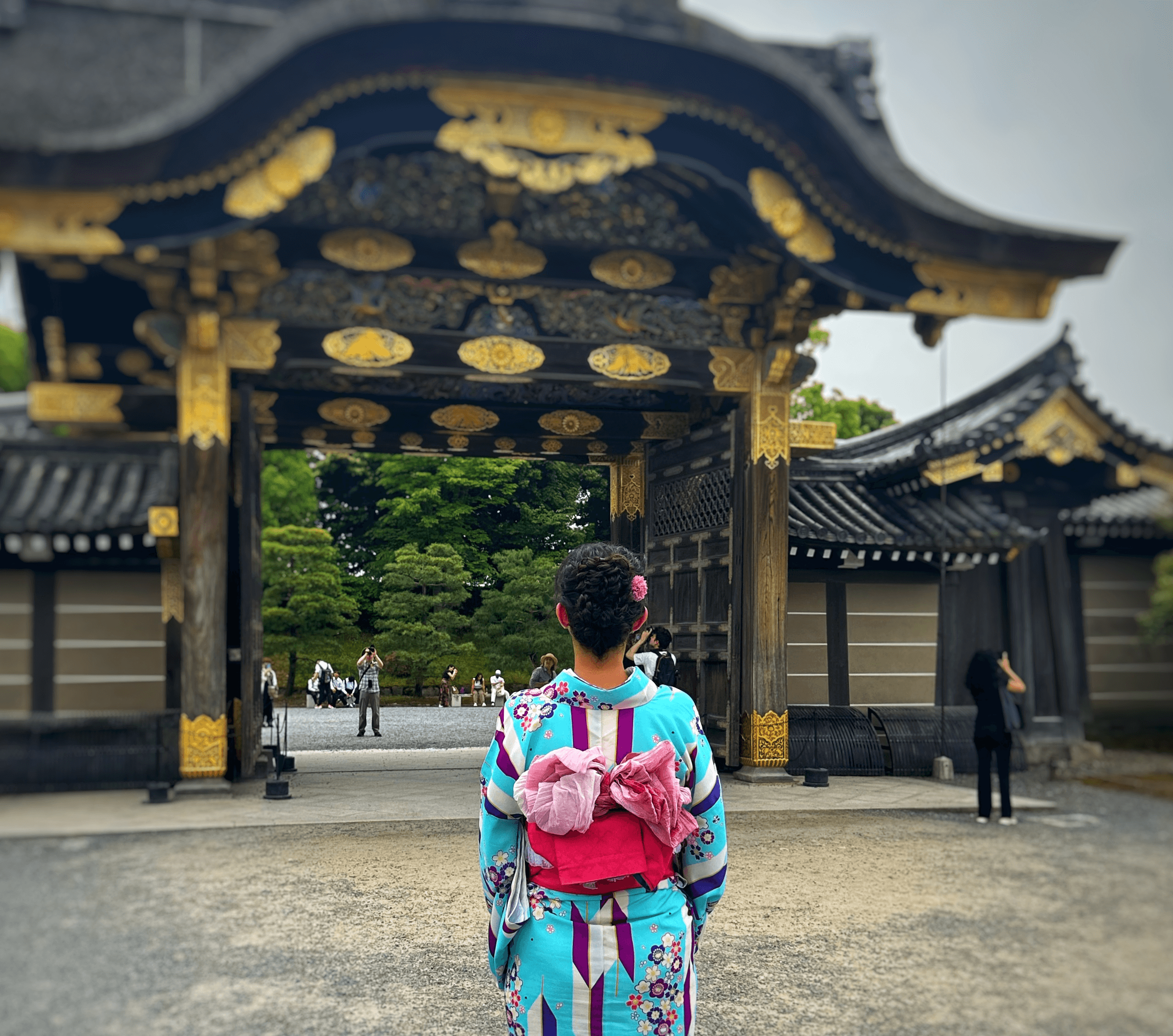 girl dressed in kimono looking into Japanese temple